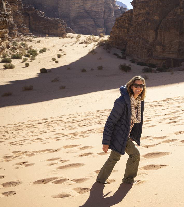 ilana walking up sand dunes in wadi rum desert traveling on vacation in jordan