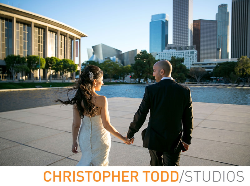 bride and groom walk towards fountain near Disney concert hall in downtown los Angeles