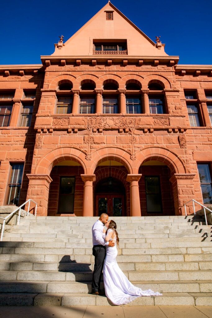 eloping couple standing on the steps in front of the old orange county courthouse
