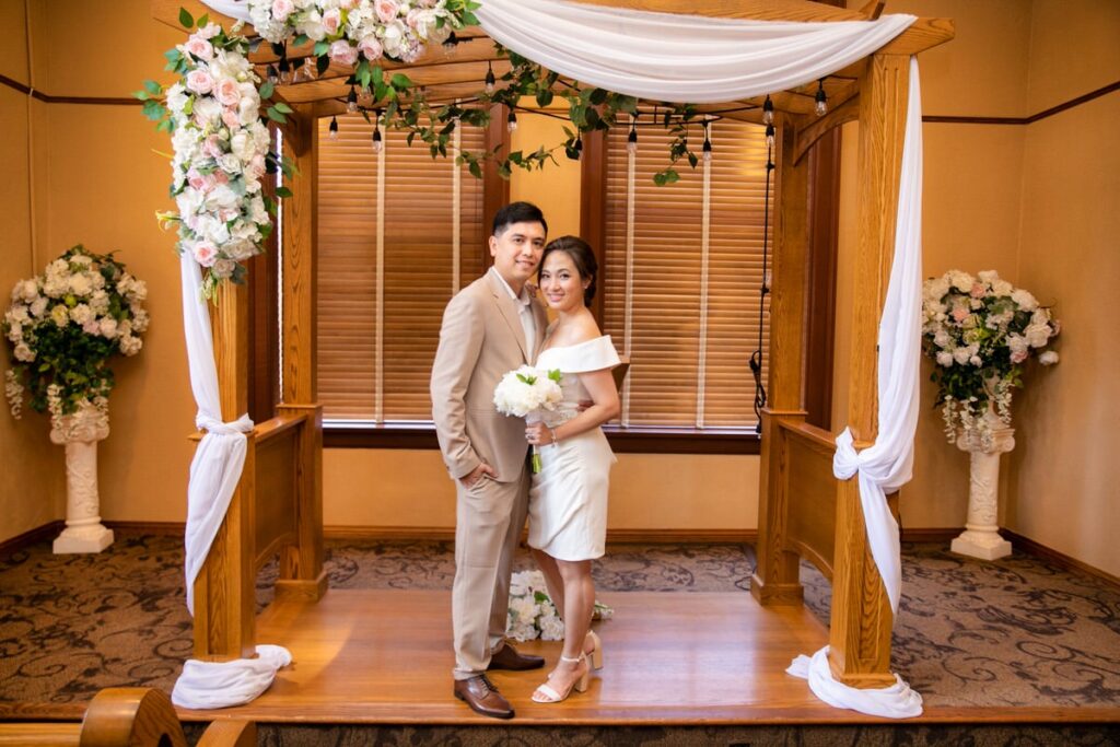 couple in old orange county courthouse ceremony room standing under decoritive arch