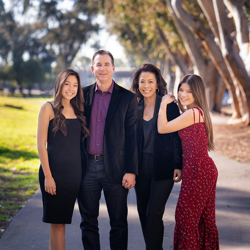 Family with teenage daughters wearing dress clothes in Central Park in Huntington Beach.