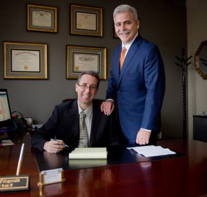 Attorney partners standing by desk in Orange County law office.