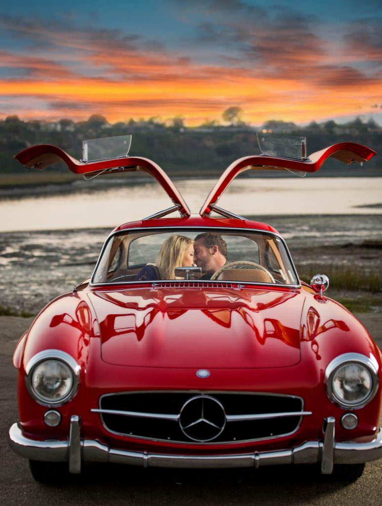 engaged couple with red mercedes