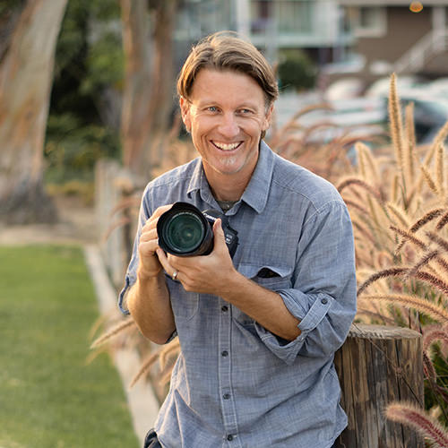 Male photographer holding camera.