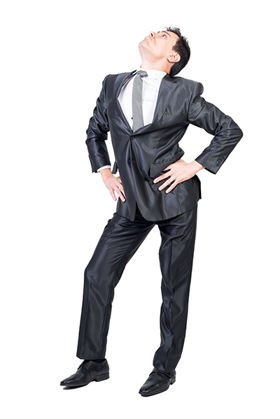 man posing in a dark colored wrinkled suit for a headshot on a white background in a photo studio