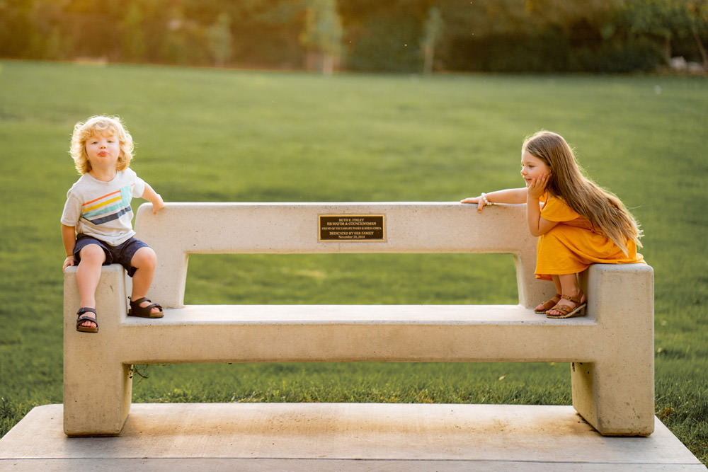 boy and girl sitting on park bench