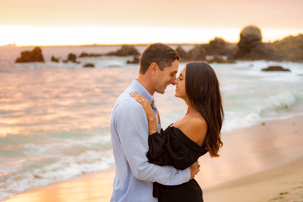 couple embracing on beach during sunset marriage proposal