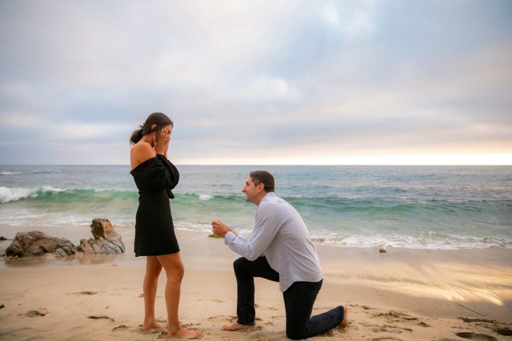 man proposing to girlfriend on beach