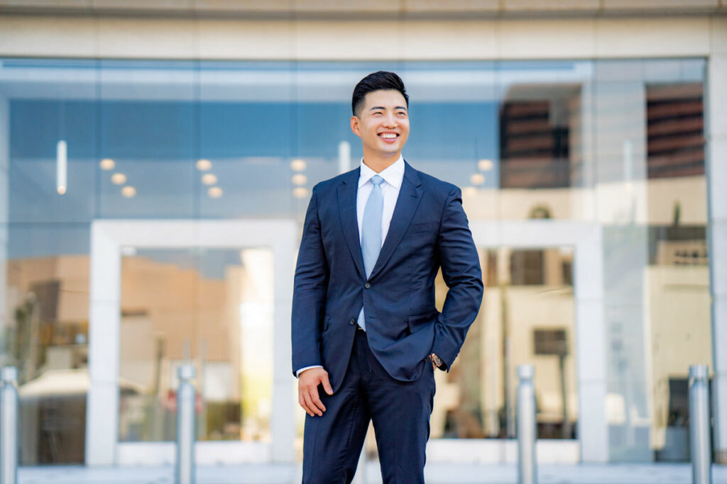 Young asian male wearing suit in front of building