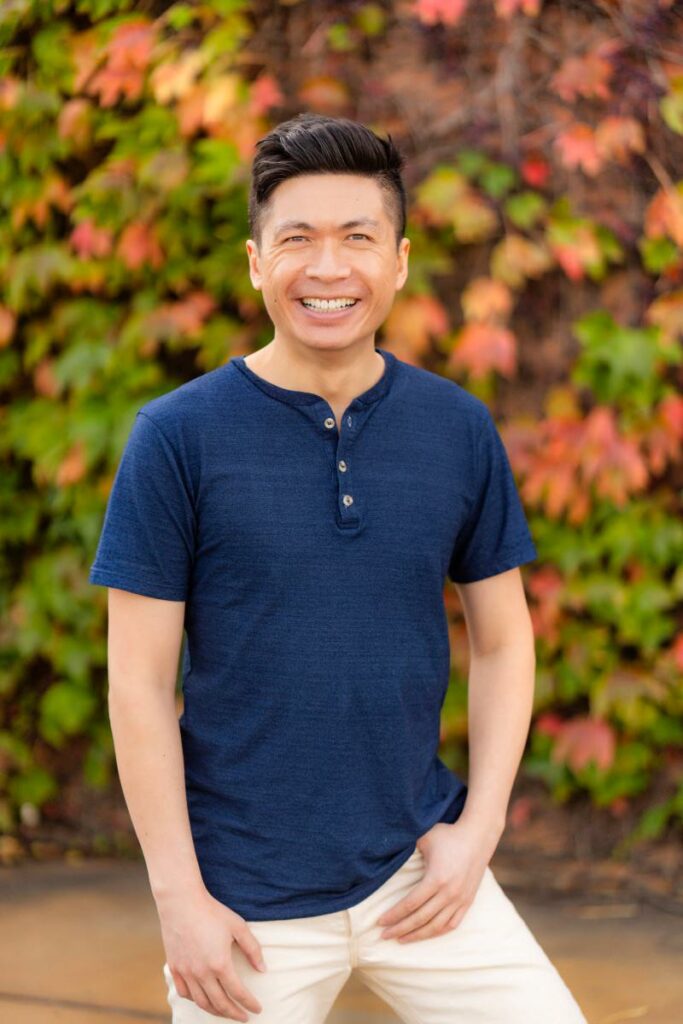 A professionally photographed dating profile picture showcases a guy's laid-back style in a classic navy blue shirt during an outdoor shoot.