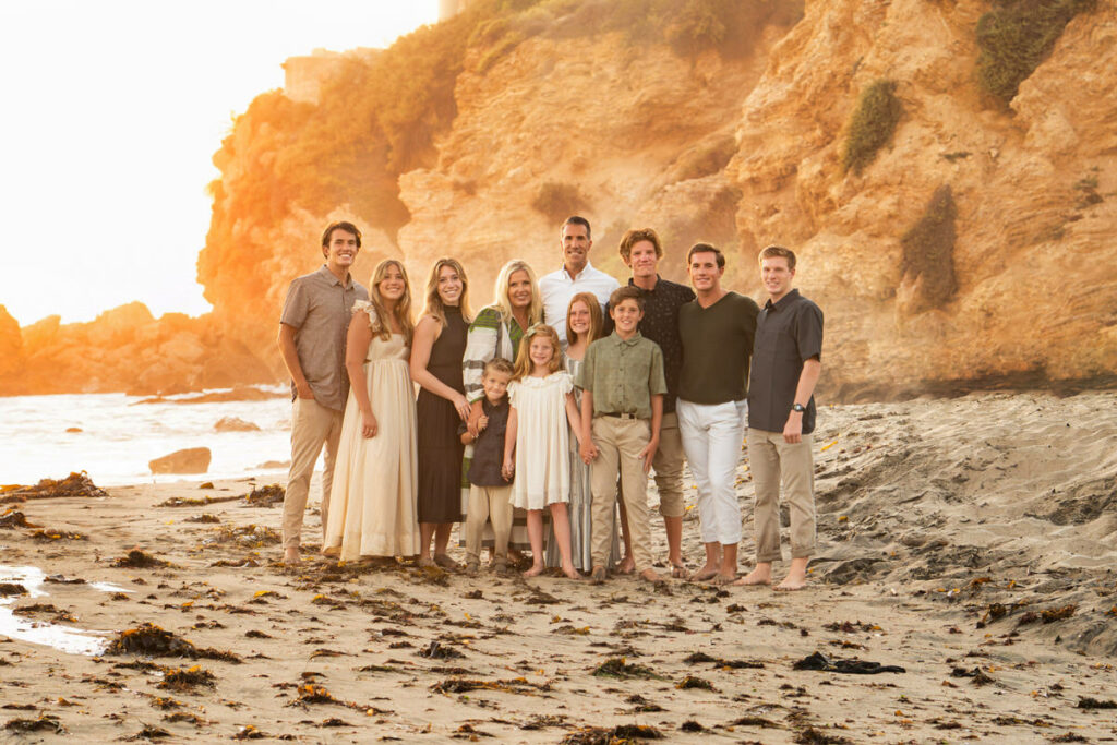 large family portrait with earthtones posing on the beach