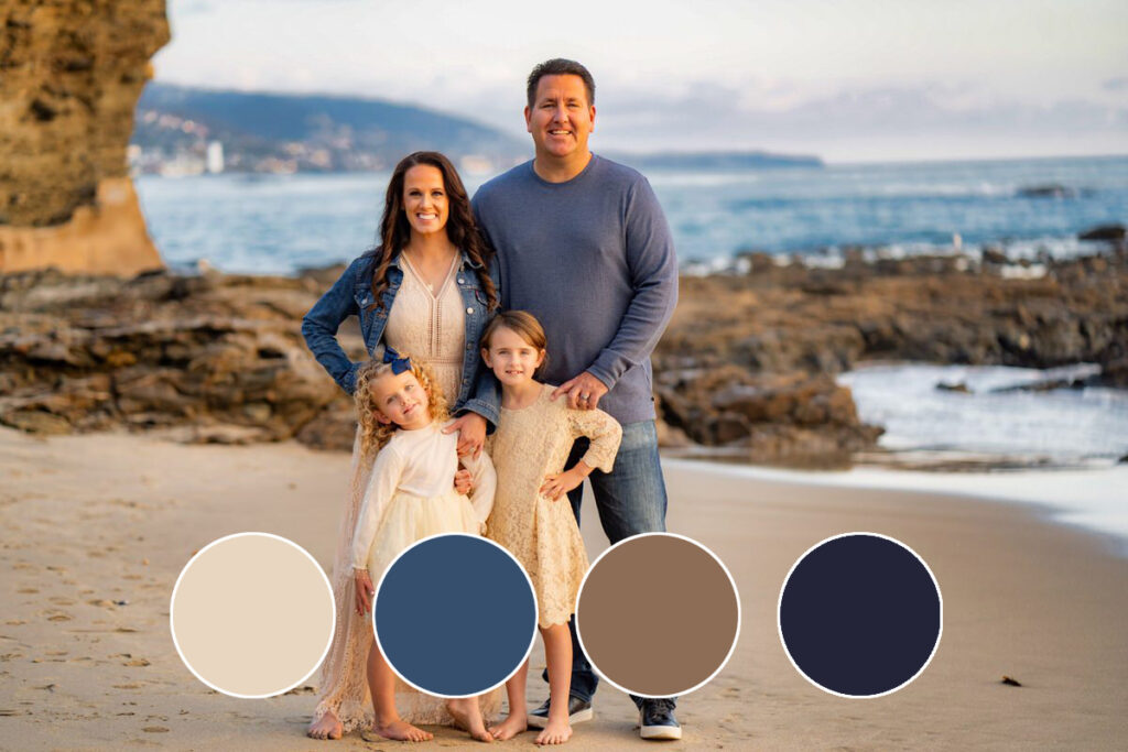 family of four standing on beach with dads hand on daughters shoulder wearing spring cool color outfits.