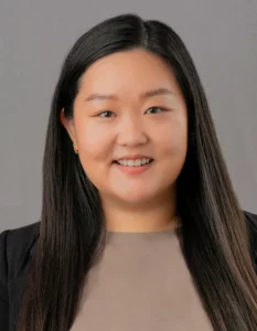 Asian women posing for ERAS headshot with gray background