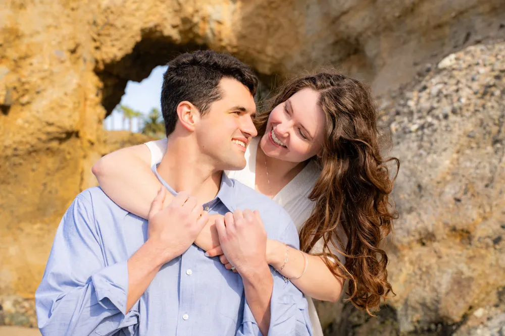 engaged couple embracing during beach photos shoot