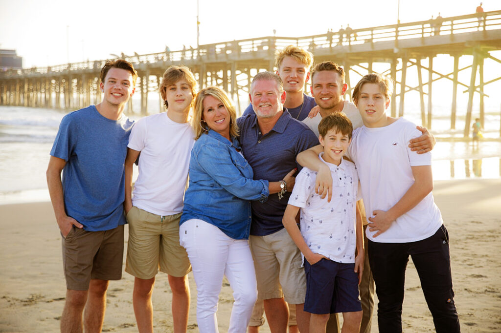 blended family with 6 boys at newport beach with pier in background